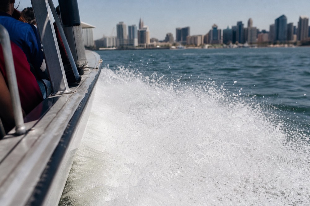 A fast open jet boat throwing spray on San Diego Bay, shallow depth of field, textures sharp